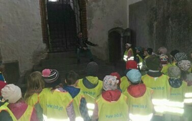 Zdjęcie przedstawia dzieci zwiedzające mury zespołu katedralno &ndash; zamkowego w Kwidzynie
