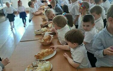 Zdjęcie przedstawia dzieci smakujące ciasto.